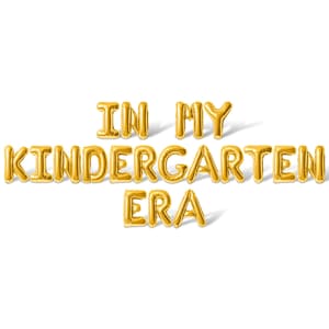 May include: Gold foil balloon letters spell out "IN MY KINDERGARTEN ERA" against a white background. The balloons cast a slight shadow, adding depth to the image. The text is centered and clearly visible.
