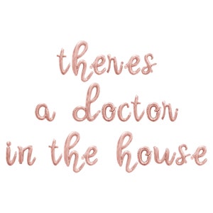 May include: Rose gold foil balloons spelling out the phrase "there's a doctor in the house".