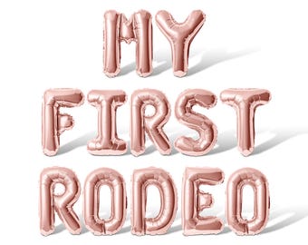 May include: Rose gold foil balloons spelling out "MY FIRST RODEO".