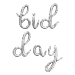 May include: Silver balloon letters spelling out "Bid Day".