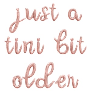 May include: Rose gold foil balloons spelling out "Just a tiny bit older".