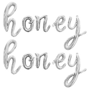 May include: Two silver foil balloons spelling out the word "honey" in a cursive font.