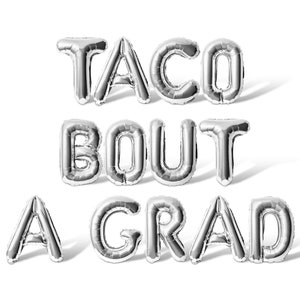 May include: Silver foil balloons spelling out "Taco Bout A Grad" on a white background.