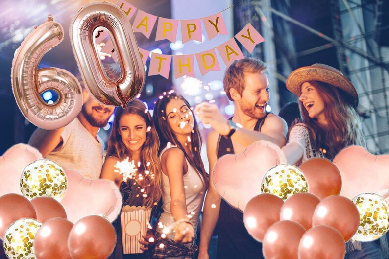 May include: A group of people celebrating a 60th birthday with rose gold balloons, confetti balloons, and a pink banner that says "Happy Birthday".