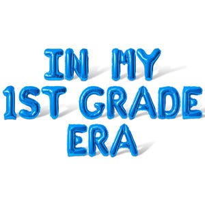 May include: Blue foil balloon letters spelling "IN MY 1ST GRADE ERA" on a white background. The balloons are inflated and casting shadows, creating a celebratory and festive look, perfect for a back-to-school theme.