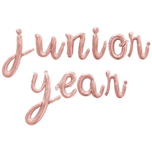 May include: Rose gold foil balloons spelling out "junior year" in a cursive font.