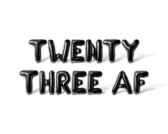 May include: Black balloon letters spelling out "TWENTY THREE AF" against a white backdrop.
