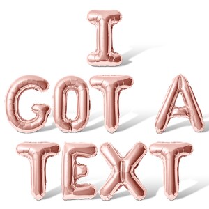 May include: Rose gold foil balloons spelling out the phrase "I GOT A TEXT".