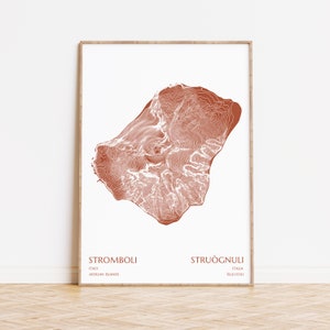 May include: A minimalist line art print of the islands of Stromboli and Struognulli. The islands are depicted in a terracotta color with white lines showing the topography. The text "Stromboli, Italy, Aeolian Islands" and "Struognulli, Italia, Isole Eolie" is printed below the islands.