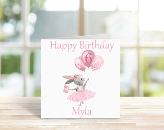 May include: A pink birthday card with a gray bunny wearing a pink tutu and holding pink balloons. The balloons have a pink number 6 on one and a pink floral pattern on the other. The card says "Happy Birthday Myla".