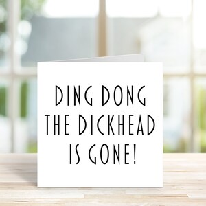 May include: A white card with black text that reads "Ding Dong The Dickhead Is Gone!"