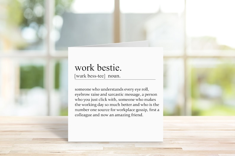 May include: A white card with black text defining "work bestie" as someone who understands every eye roll, eyebrow raise, and sarcastic message. The card says a work bestie is someone you just click with, who makes the working day better, and is the number one source for workplace gossip. It concludes by saying a work bestie is first a colleague and now an amazing friend.