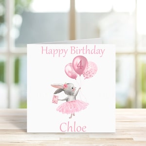 May include: A pink birthday card featuring a grey bunny wearing a pink tutu and holding pink balloons. The card reads "Happy Birthday" and "Chloe" and has the number "4" on one of the balloons.