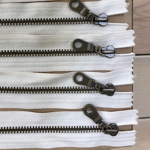 Zipper- copper- antique brass colour. Sold in group of 4’s. Free shipping in Canada