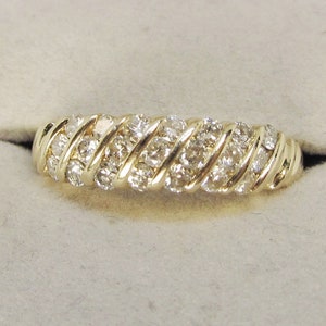 May include: A gold band ring with a twisted design set with small diamonds.