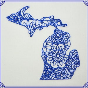 Może przedstawiać: Kontur stanu Michigan wyszyty na niebiesko, wypełniony misternymi wzorami kwiatowymi.