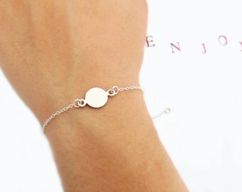 May include: A silver chain bracelet with a round silver charm. The charm is blank and can be engraved.