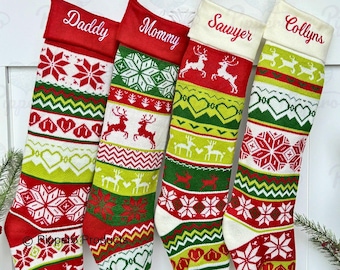 May include: Four red, green, and white Christmas stockings with a snowflake and reindeer pattern. The stockings are personalized with the names "Daddy", "Mommy", "Sawyer", and "Collyn's".