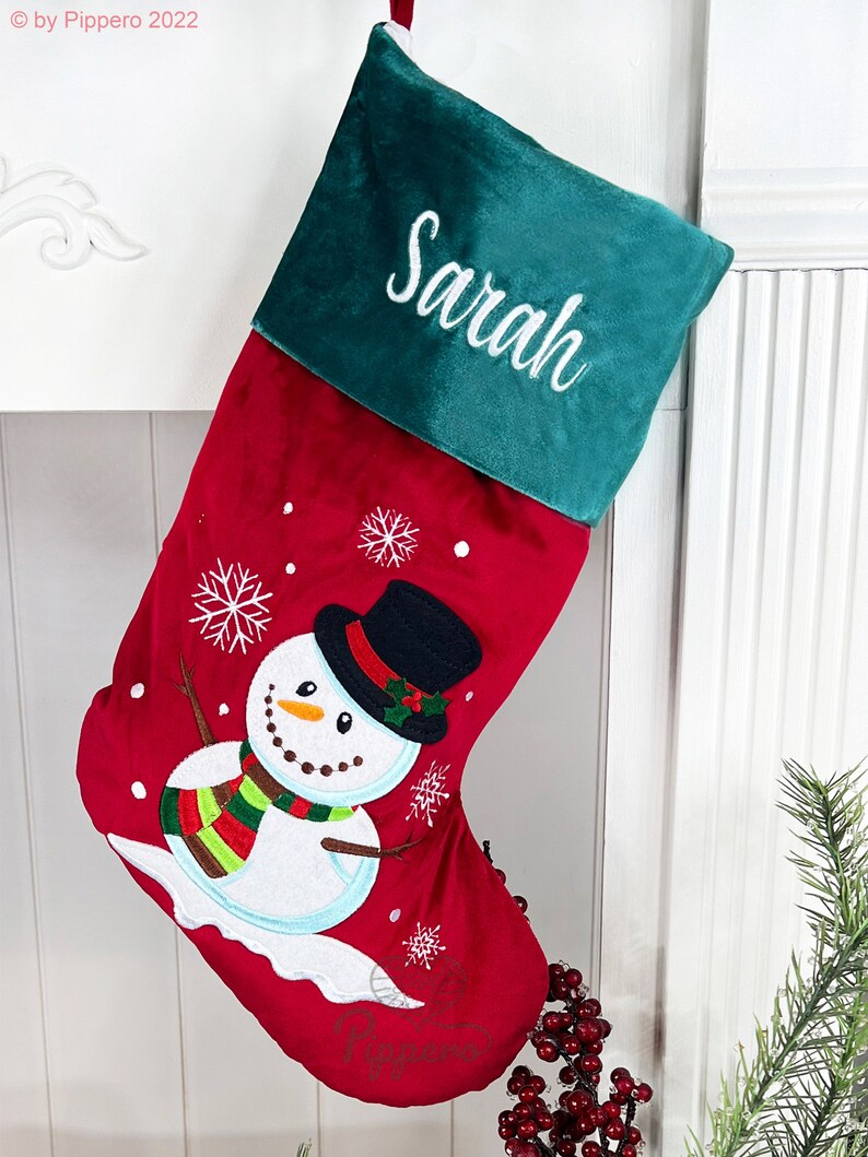 May include: Red and green Christmas stocking with a snowman design and the name "Sarah" embroidered on the cuff.