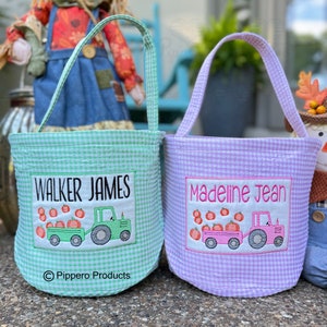 Op de afbeelding: Twee gepersonaliseerde groene en paarse gingham stoffen trick-or-treat tassen met geborduurde namen, "Walker James" en "Madeline Jean", en een tractor die pompoenen vervoert.
