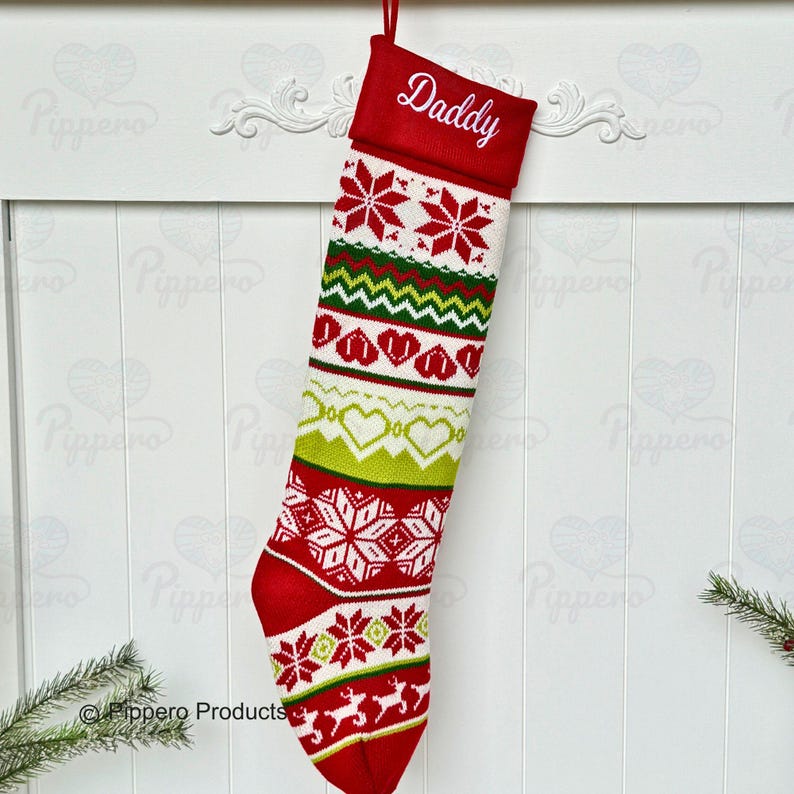 May include: Red and green knitted Christmas stocking with a white snowflake pattern and the word "Daddy" embroidered on the cuff.
