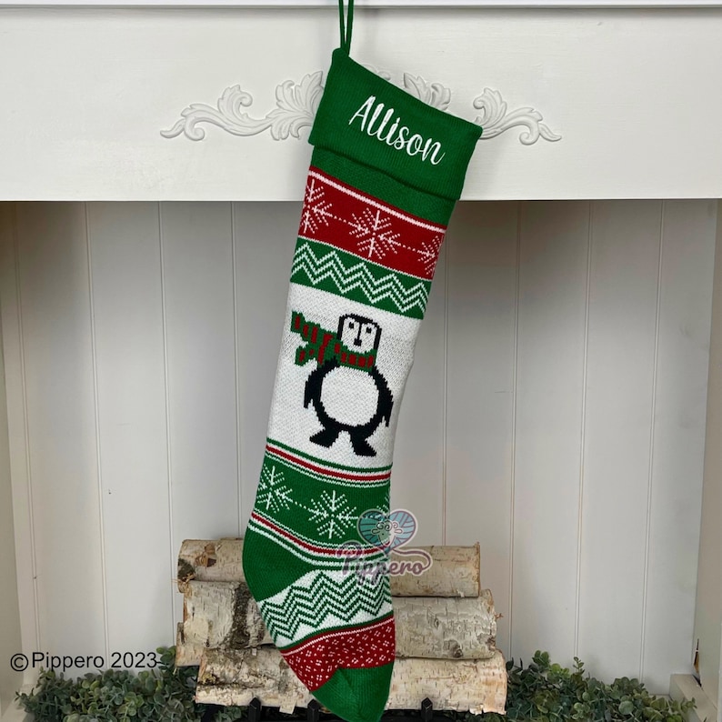 May include: Green and white knitted Christmas stocking with a penguin design and the name "Allison" embroidered on the cuff.