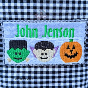 May include: A Halloween-themed patch with the name "John Jenson" embroidered in green. Below the name are embroidered images of Frankenstein's monster, a vampire, and a jack-o'-lantern. The patch is on a black and white checkered background.