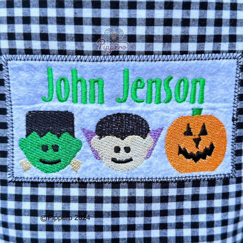 May include: A Halloween-themed patch with the name "John Jenson" embroidered in green. Below the name are embroidered images of Frankenstein's monster, a vampire, and a jack-o'-lantern. The patch is on a black and white checkered background.