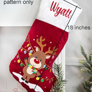 May include: Red and white Christmas stocking with a reindeer and lights design. The stocking is 18 inches long and 7 inches wide. The name Wyatt is embroidered on the stocking.