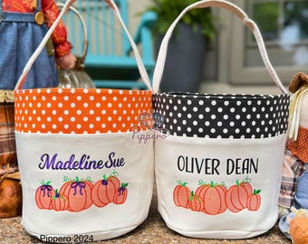 May include: Two personalized Halloween trick-or-treat bags with orange and black polka dot fabric. One bag says "Madeline Sue" and the other says "Oliver Dean". Both bags feature embroidered pumpkins.