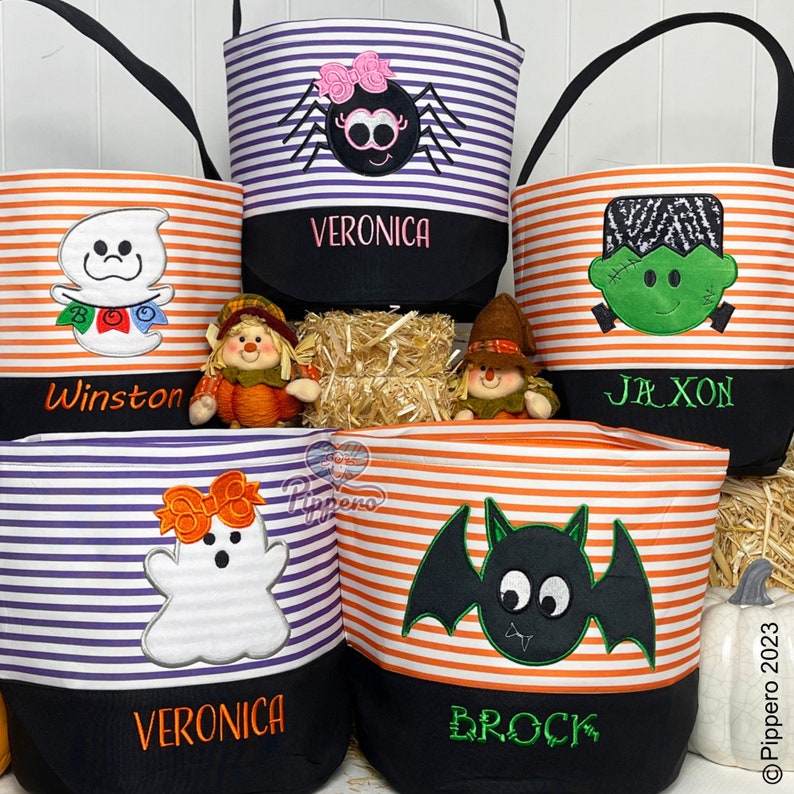 May include: Four Halloween trick-or-treat bags with different designs. The bags are striped in orange and purple or orange and white. The designs include a ghost, a spider, a bat, and Frankenstein. Each bag has a black bottom with a name on it: Winston, Veronica, Brock, and Jaxon.