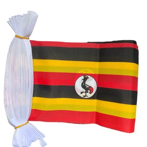 Op de afbeelding: Een Oegandese vlaggenlijn met een geel elastiekje. De vlag is zwart, geel en rood met een zwarte gekroonde kraanvogel in een witte cirkel in het midden.