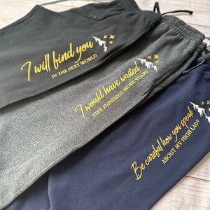 K&ouml;nnte beinhalten: Drei Jogginghosen in Anthrazit, Hellgrau und Marineblau. Jede Hose hat eine goldene Grafik und den Text: "I will find you in the next world", "I would have waited five hundred more years" und "Be careful how you speak about my high lady."