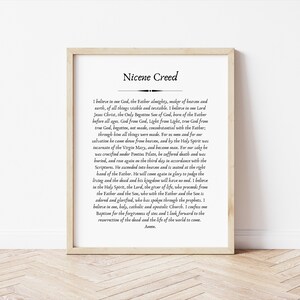 May include: A printable poster with a black and white text document featuring the Nicene Creed. The text is centered on a white background with a black border. The poster is framed in a light brown wood frame.