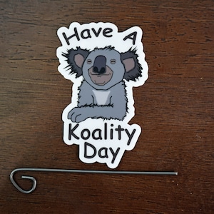 May include: A white sticker with a cartoon koala bear and the text "Have a Koality Day".