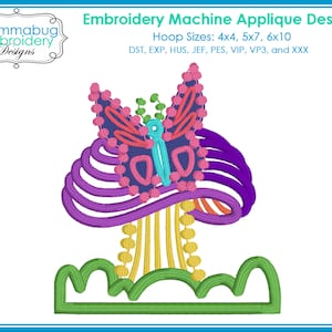 May include: Embroidered applique design of a purple and pink mushroom with a butterfly on top. The mushroom has a yellow stem and is surrounded by green grass. The design is available in multiple hoop sizes: 4x4, 5x7, and 6x10. File formats include DST, EXP, HUS, JEF, PES, VIP, VP3, and XXX.