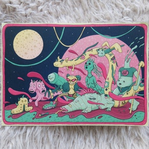 May include: A colourful illustration of seven fantastical creatures against a night sky backdrop. The creatures are pink, green, yellow, and blue with various features such as multiple eyes, long necks, and tails. The background features a large moon and stars.