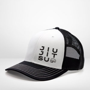 May include: White and black trucker hat with a black embroidered logo that says "JIU JITSU" with a fist symbol.