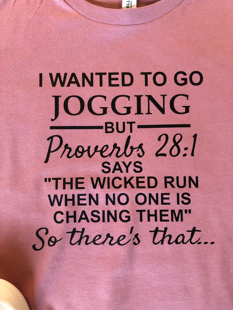May include: A pink t-shirt with black text that reads "I wanted to go jogging but Proverbs 28:1 says "The wicked run when no one is chasing them." So there's that..."