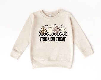 Puede incluir: Sudadera beige con un diseño de Halloween. El diseño incluye cuatro fantasmas de dibujos animados con diferentes patrones, un borde a cuadros blanco y negro y el texto "TRICK OR TREAT" en negro.