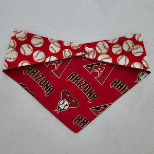 May include: Red and white baseball-themed dog bandana with the Arizona Diamondbacks logo and the word "Arizona" repeated on the bandana.