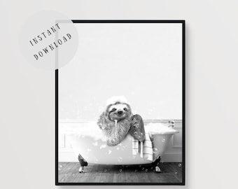 May include: A black and white photograph of a sloth taking a bath in a white bathtub with bubbles. The sloth is sitting in the tub with its arms resting on the edge. The sloth has a relaxed expression on its face.