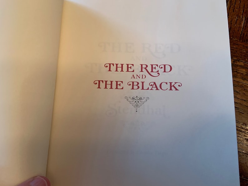 May include: The cover of a book titled "The Red and The Black" with a decorative flourish below the title.