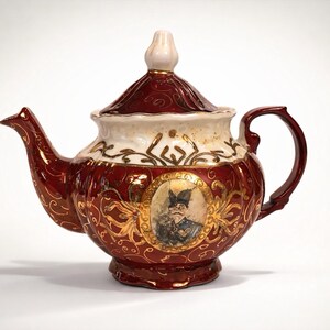 Tetera de porcelana vintage: Tetera de porcelana roja y blanca para coleccionistas y decoración.