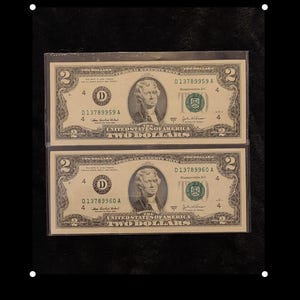 May include: Two $2 bills, both with the serial number D13789959A and D13789960A. The bills are in a plastic sleeve and are in good condition.