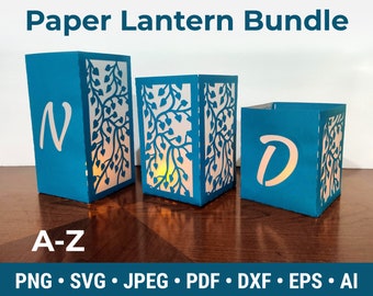 Pode incluir: Um conjunto de três lanternas de papel azul turquesa com um design de folhas e as letras N e D. As lanternas são para artesanato e podem ser usadas como decoração.