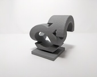 Pode incluir: Uma escultura abstrata cinza feita de três peças que se encaixam. A escultura é feita de um material áspero e texturizado e tem uma forma orgânica única.