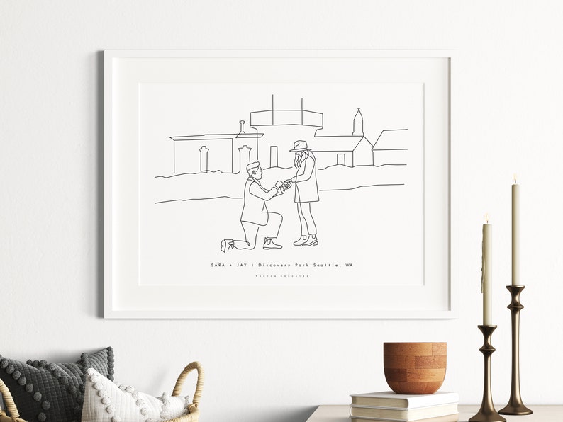 May include: A framed line art print depicting a marriage proposal scene in Discovery Park, Seattle, WA. The black and white illustration shows a person kneeling and offering a ring to another person. The print is displayed on a white wall.
