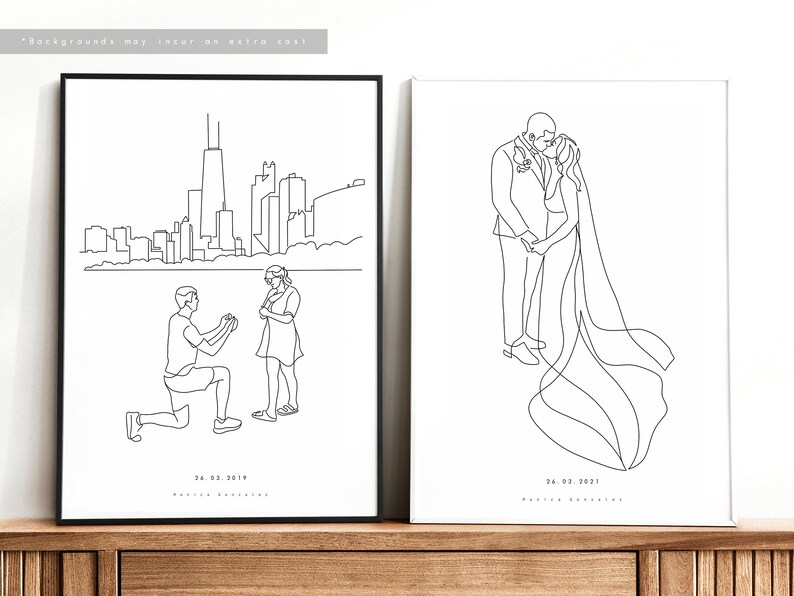 May include: Two framed line art prints. One depicts a proposal scene with a city skyline, the other a kissing couple. Both are black and white, with dates and names below the images. The frames are black.
