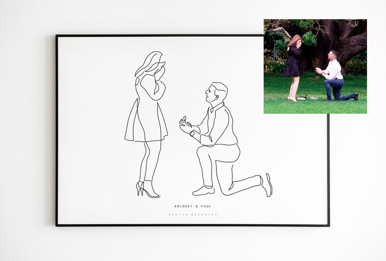 May include: A framed black and white line art print depicting a marriage proposal. The artwork shows a man kneeling and offering a ring to a woman. The names "Bridget & Paul" are printed below the figures. A color photo of the couple is in the upper right corner.